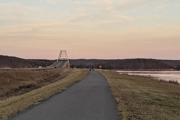 Image of two people walking on a paved path.